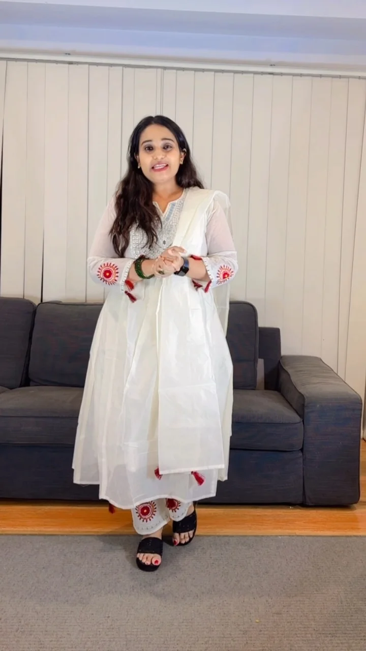 White Anarkali Salwar Suit with Mirror Work Yoke and Red Tassels