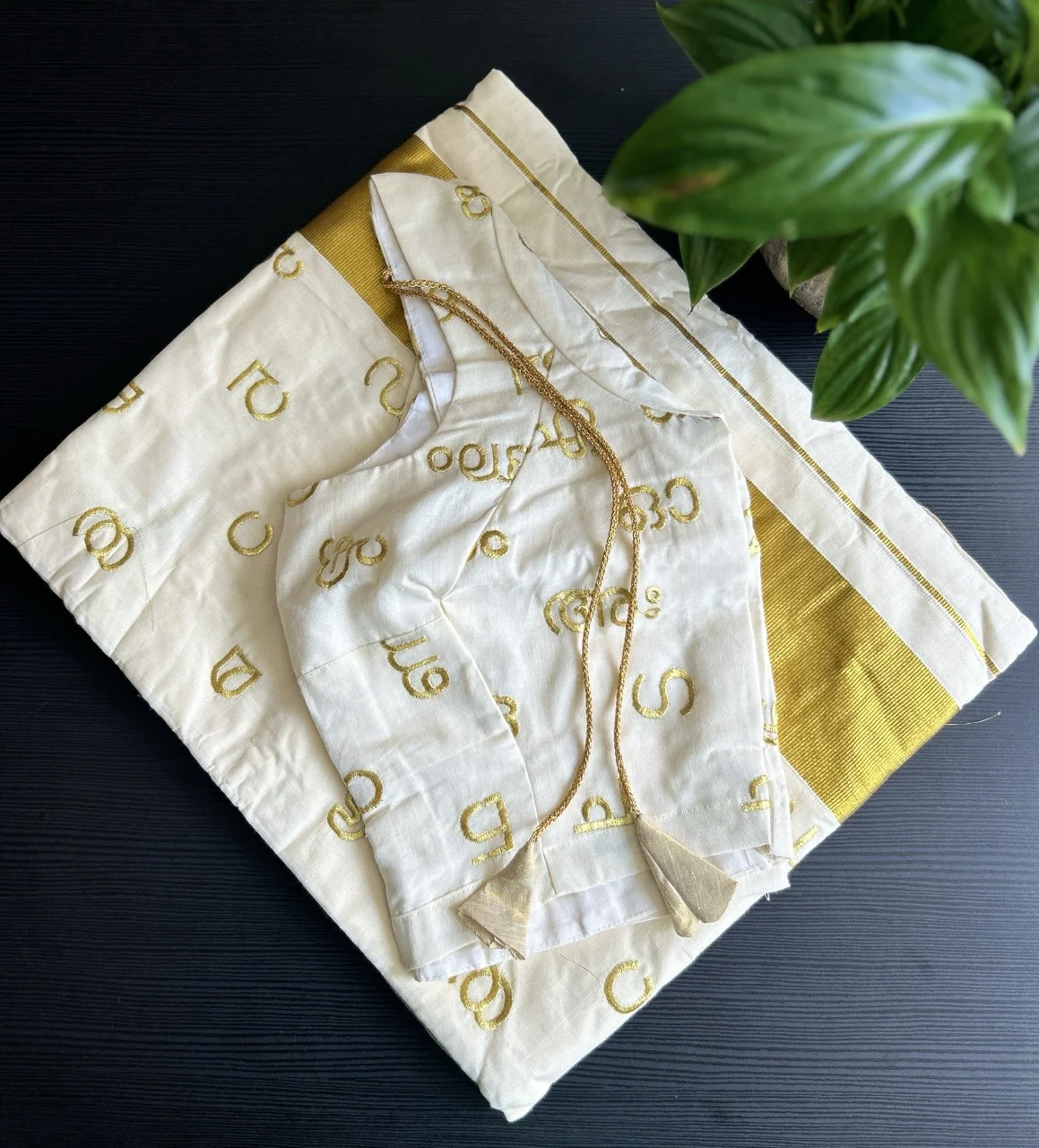 White and Gold Kerala Saree with Malayalam Script Motifs and a Matching Blouse.