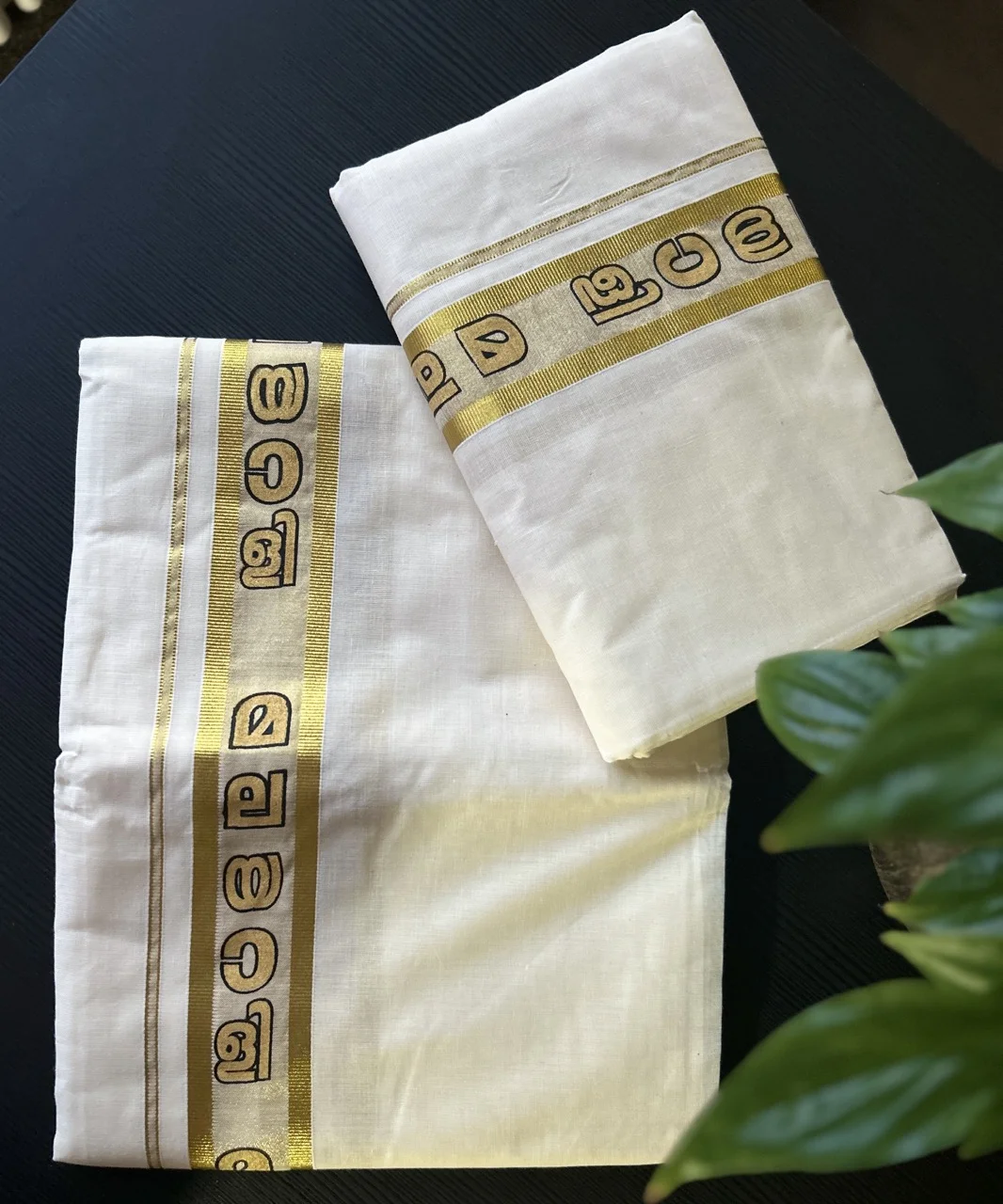 White and Gold Kerala Kasavu Saree with a Border Featuring Malayalam Script